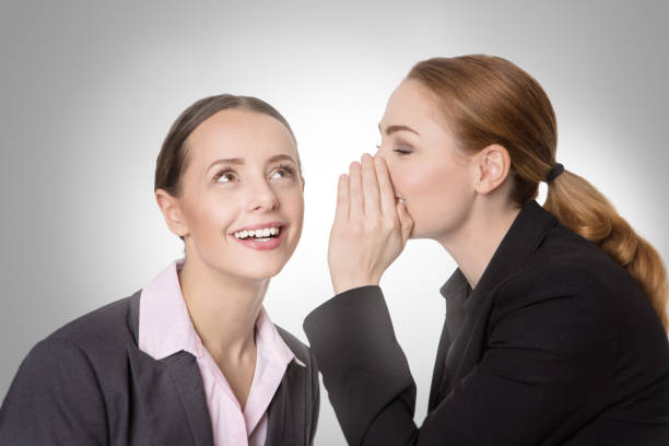 istock coworkers sharing a secret 695662980