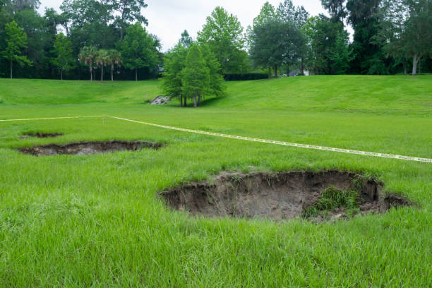 Sinkholes in a Lush Green Park Sinkholes in open in a grassy field in a park-like setting. sinkhole stock pictures, royalty-free photos & images