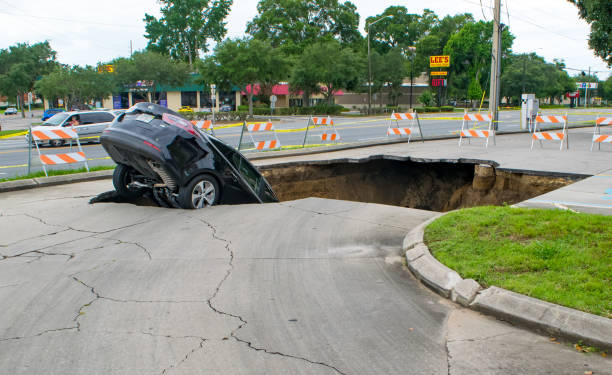 Sinkhole Swallows a Car in Florida Ocala, Florida, USA - June 11, 2017: A large sinkhole opens in a parking area and swallows a car that teeters on the edge. sinkhole stock pictures, royalty-free photos & images