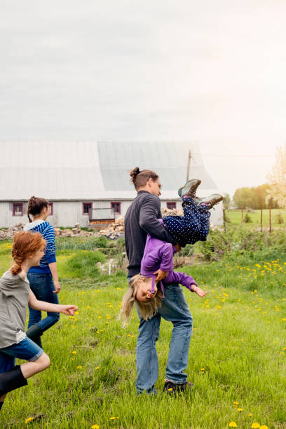 istock Kids playing with dad around house in springtime. 695667672