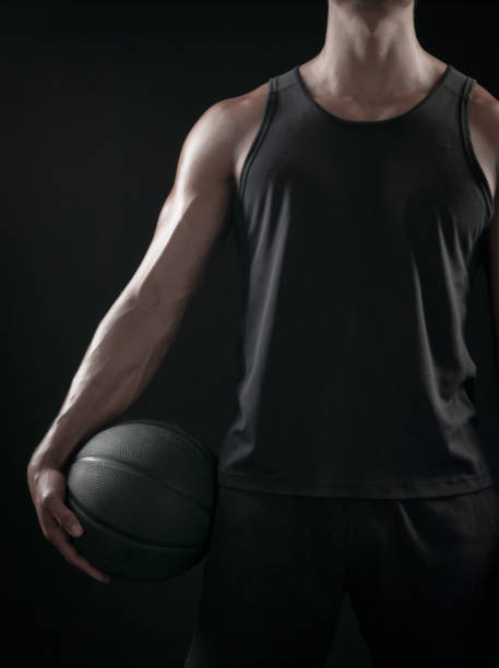 istock Man Holding a Basketball On A Black Background 695670874