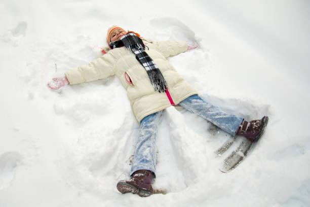 istock Young girl making a snow angel 695671540
