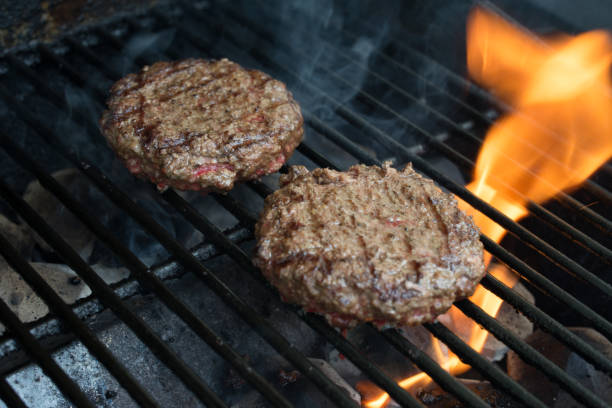 istock Two hamburgers on the grill 695685604