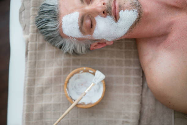 homme, obtenir un masque facial au spa - massaging men beauty spa beauty treatment photos et images de collection