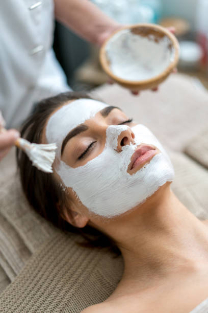 retrato de la belleza de una mujer recibiendo un facial en el spa - health spa women spa treatment massager fotografías e imágenes de stock