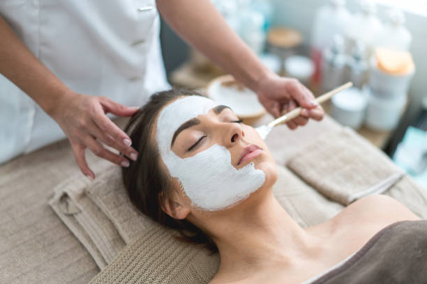 hermosa mujer consigue una máscara facial en el spa - health spa women spa treatment massager fotografías e imágenes de stock