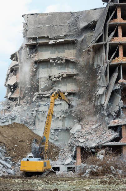 istock Remove dangerous building in an urban area with an excavator 695686478