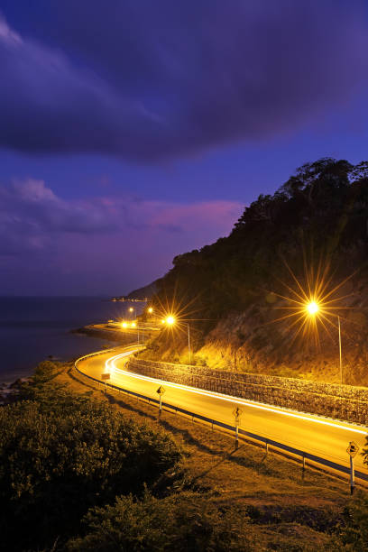 istock Twilight at curved road with seaside in a long exposure 695693074