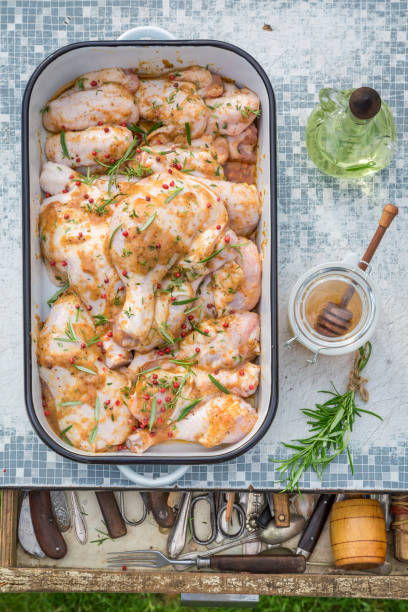 Seasoning fresh chicken legs with herbs for grill