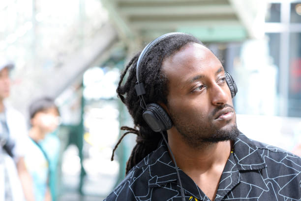 istock Man walking outside with headphones on 695702266