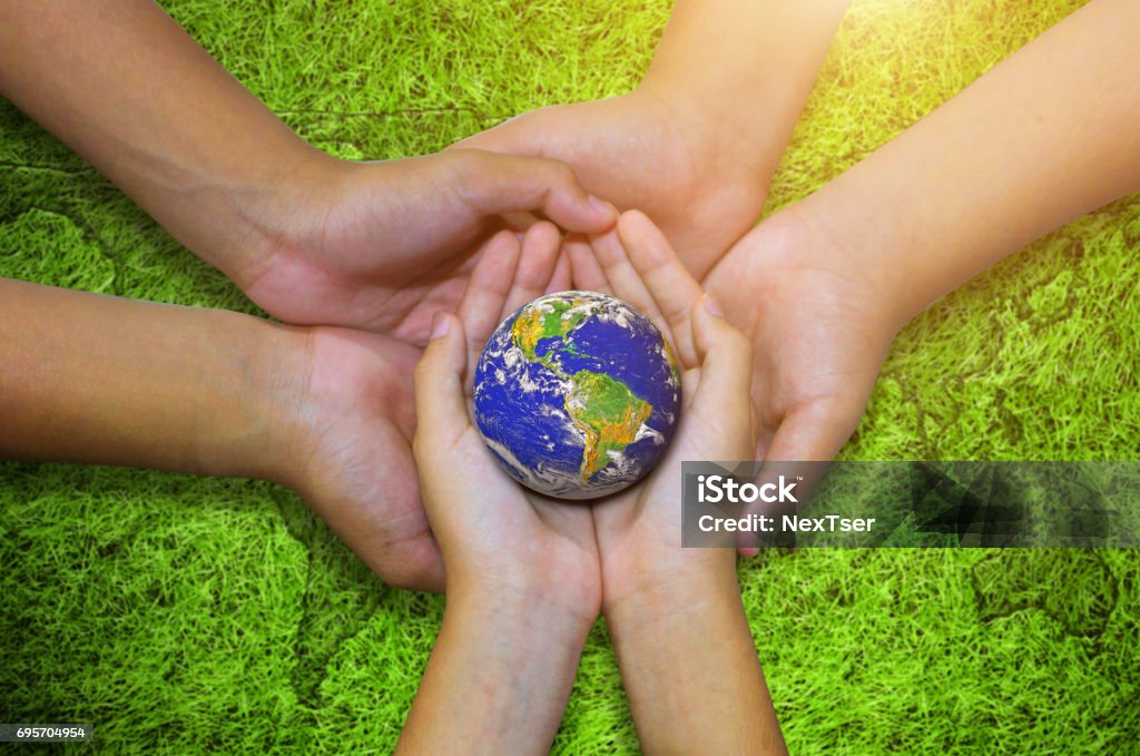 Earth planet in  asian Children hand green grass background Earth planet in asian Children hand on green grass background. - Elements of this image furnished by NASA Business Stock Photo