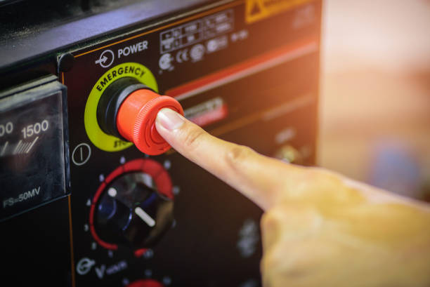 Finger push on red emergency stop switch welding machine in steel industry.