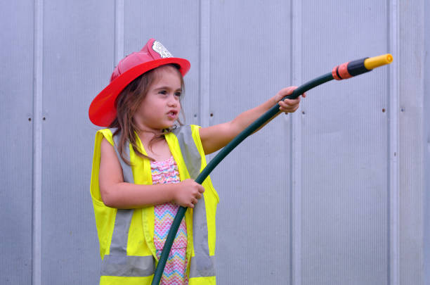 bambina in costume da pompiere - child playing dressing up imagination foto e immagini stock