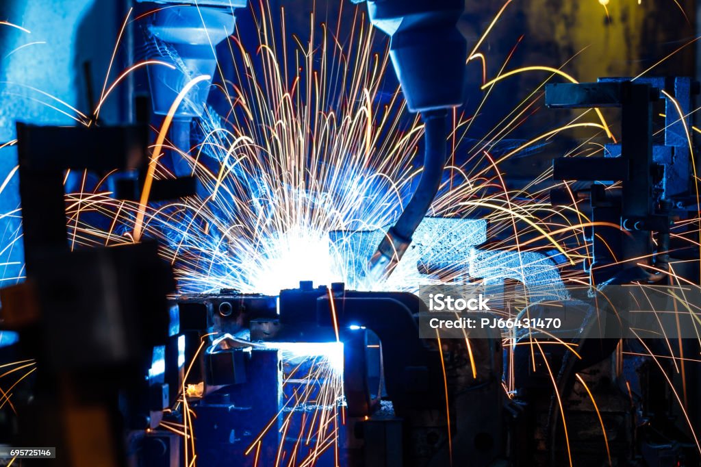 Welding robots in factory Welding robots movement in a car factory (manufacturing, industry, factory) Car Stock Photo
