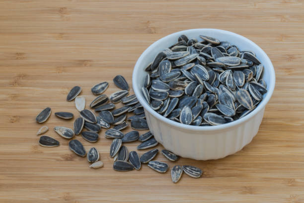istock sunflower seeds in a white bowl. 695727784