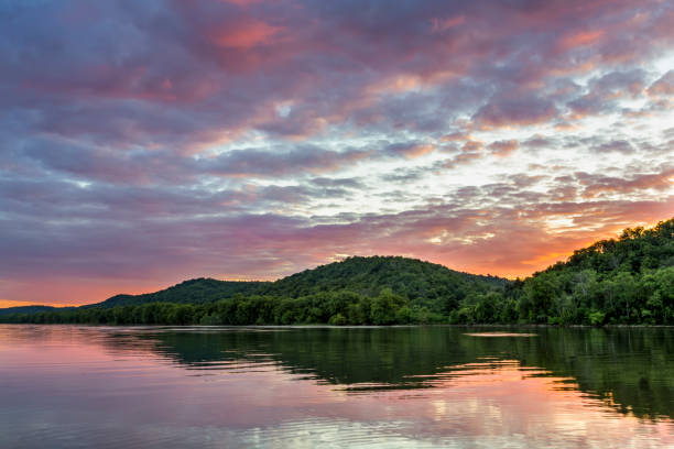 Sundown on the Ohio River A colorful sunset sky is reflected on the Ohio River as photographed from the shore at Paden City, West Virginia looking across to the Ohio side of the river. ohio river photos stock pictures, royalty-free photos & images