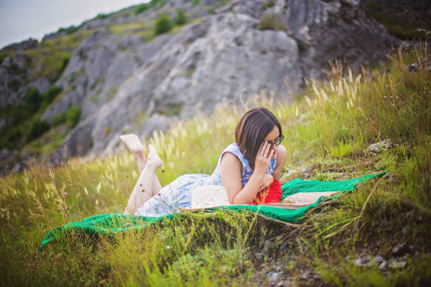 istock Girl Reading in Grass 695733258