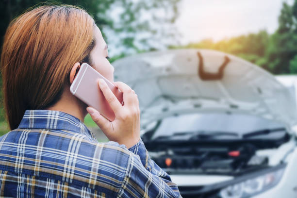 istock young Woman calling for assistance with his car broken down by the roadside 695740164