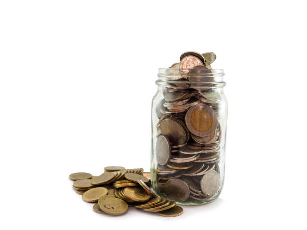 istock Many coins for saving in glass jar on white background 695740526
