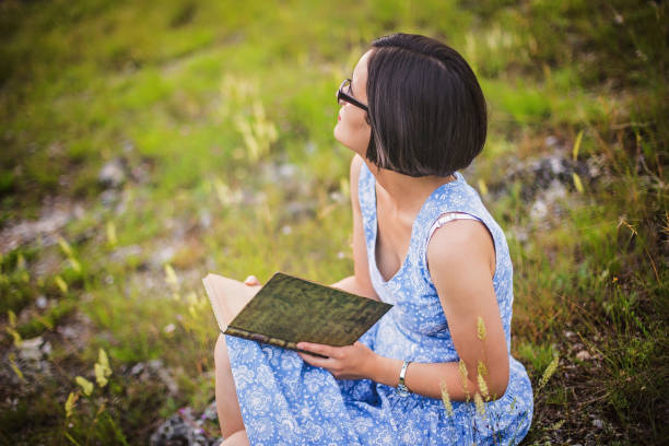 istock Portrait of holding book looking away 695740964