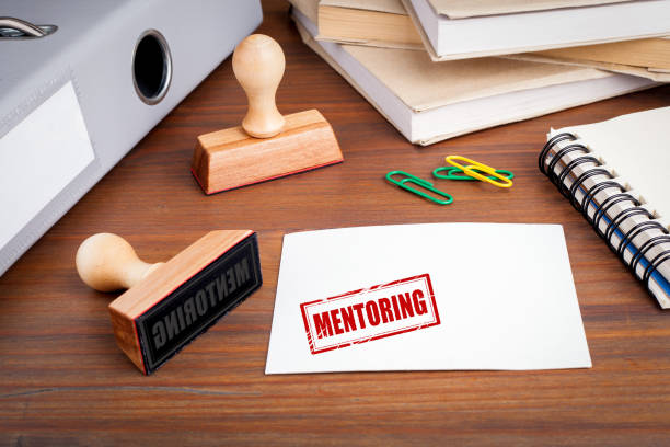 istock Mentoring concept. Rubber Stamp on desk in the Office 695748232