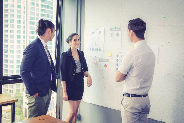 istock Three business people in modern office looking report and analyzing with talking in meeting room. 695757070
