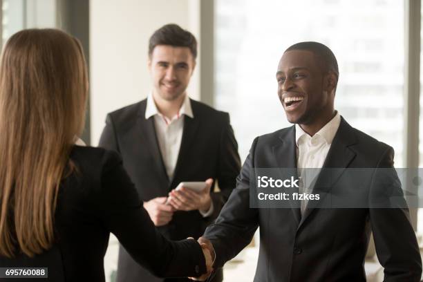 Lächelnde Afro Amerikanischen Geschäftsmann Und Kaukasischen Geschäftsfrau Handshaking Erster Eindruck Stockfoto und mehr Bilder von Geschäftsleute