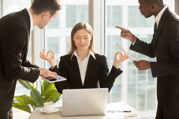 beautiful businesswoman meditating at workplace, ignoring work and annoying colleagues - yoga meditating business group of people imagens e fotografias de stock