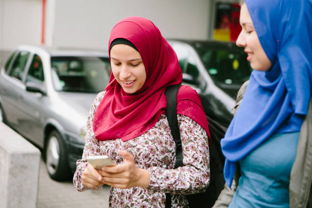 istock Friendship: two women with hijab using smart phone 695763824