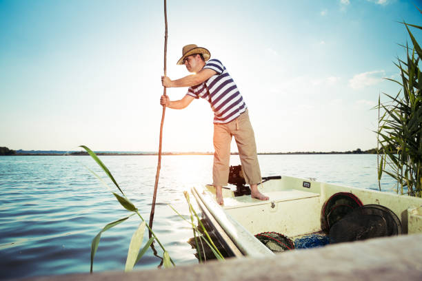 istock Fisherman pushing boat from the river bank 695764096