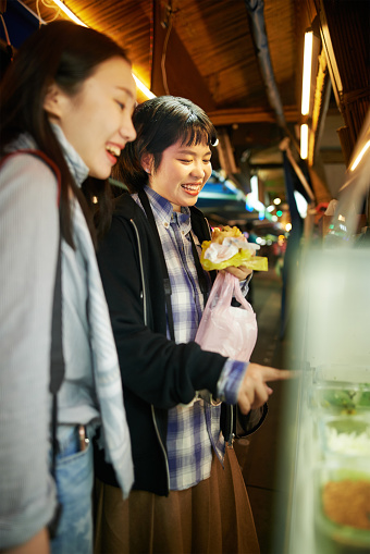 Shot of two young women buying food at a Taiwanese night market
