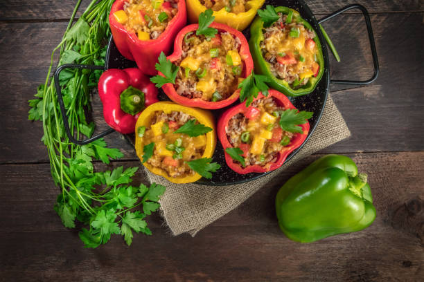 Bell peppers, stuffed with meat and rice, with copyspace An overhead photo of stuffed bell peppers with fresh parsley and a green pepper, with a place for text stuffed pepper stock pictures, royalty-free photos & images