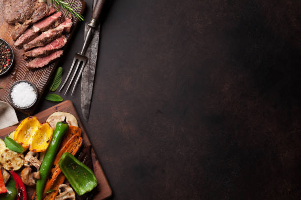istock Beef steak and grilled vegetables on cutting board 695773342