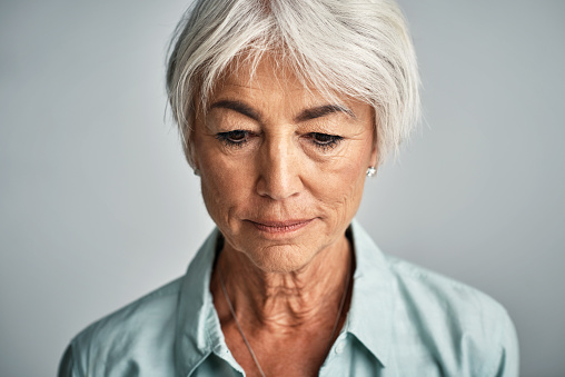 Studio shot of a senior woman posing against a grey background