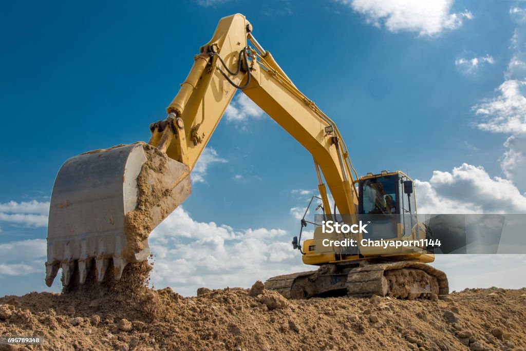 excavator blue sky heavy machine construction site Backhoe Stock Photo