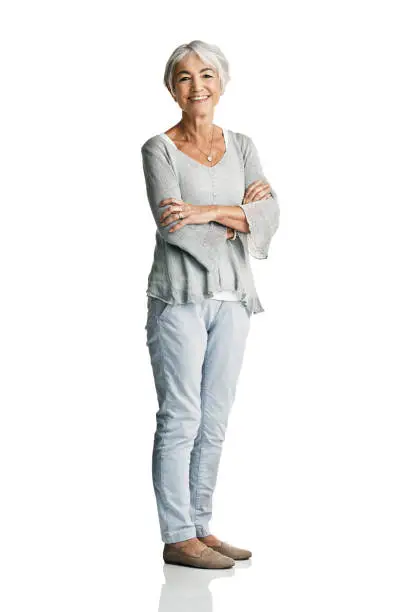 Studio portrait of a senior woman posing with her arms crossed against a white background