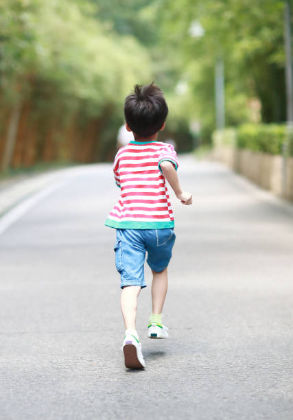 istock Little boy running in the park 695793124