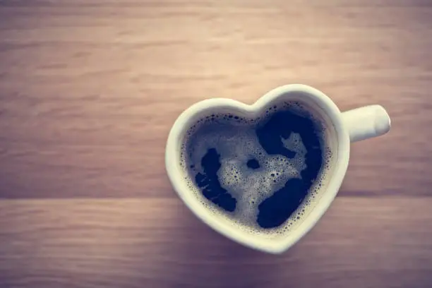 Photo of Black coffee, espresso in heart shaped cup. Love, Valentine's Day, vintage