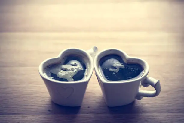 Photo of Black coffee, espresso in two heart shaped cups.. Love, Valentine's Day, vintage