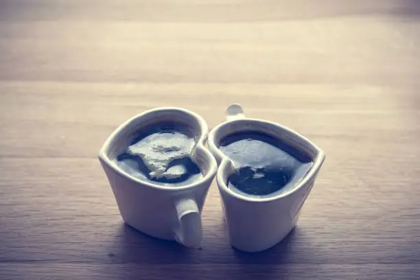 Photo of Black coffee, espresso in two heart shaped cups.. Love, Valentine's Day, vintage