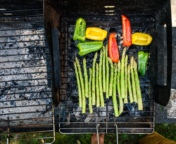 istock Asparagus and bell peppers on a barbecue bbq charcoal grill. 695838884