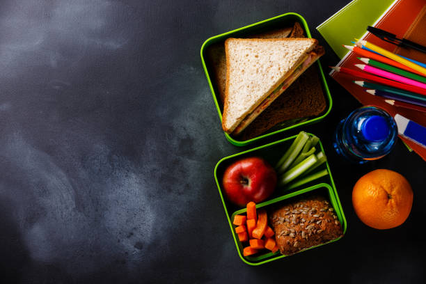 lunch box met sandwiches, fles water en school supplies - schoollunch stockfoto's en -beelden
