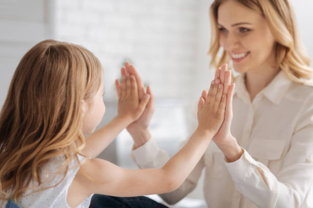 istock Little daughter comparing her hand size with mums 695843028