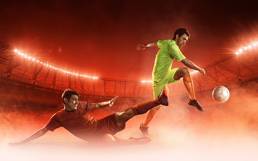 two soccer players on a field fighting for a soccer ball on red smoke background