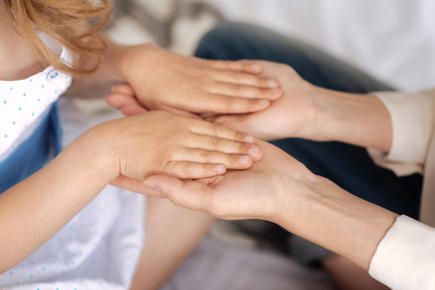 istock Delicate female hands holding hands of child 695845516