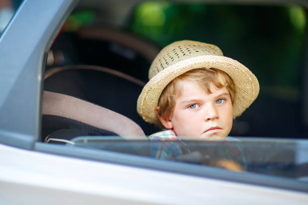 istock Sad tired kid boy sitting in car  during traffic jam 695845878