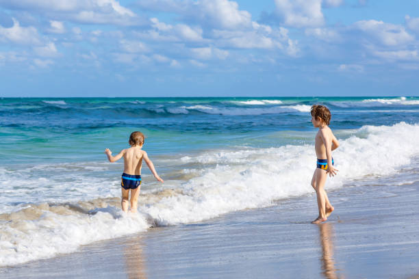 istock Two kid boys running on ocean beach in Florida 695846026