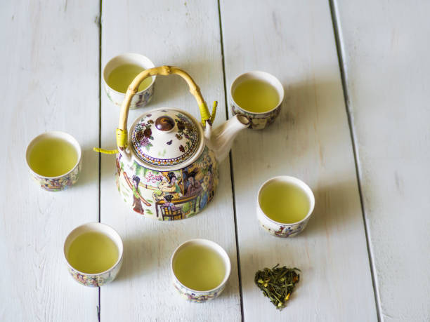 istock Green tea teapot white board backgroun healthy drink 695847104