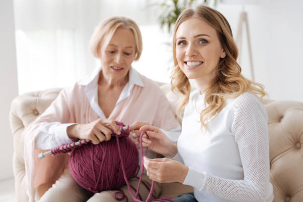 istock Young woman helping her mother with threads 695855232
