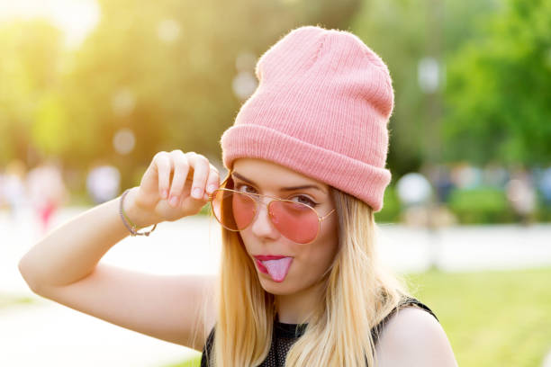 Hipster Girl in pink Beanie Hat in park stock photo